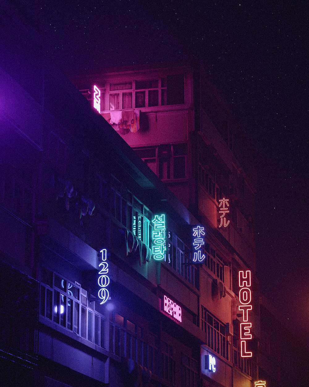 A neon-lit apartment tower against a starry night sky.